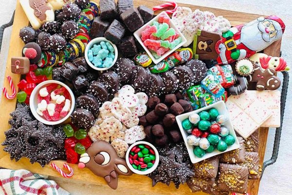 A festive tray of Christmas chocolates and candies displayed on a table, reminiscent of charcuterie boards.