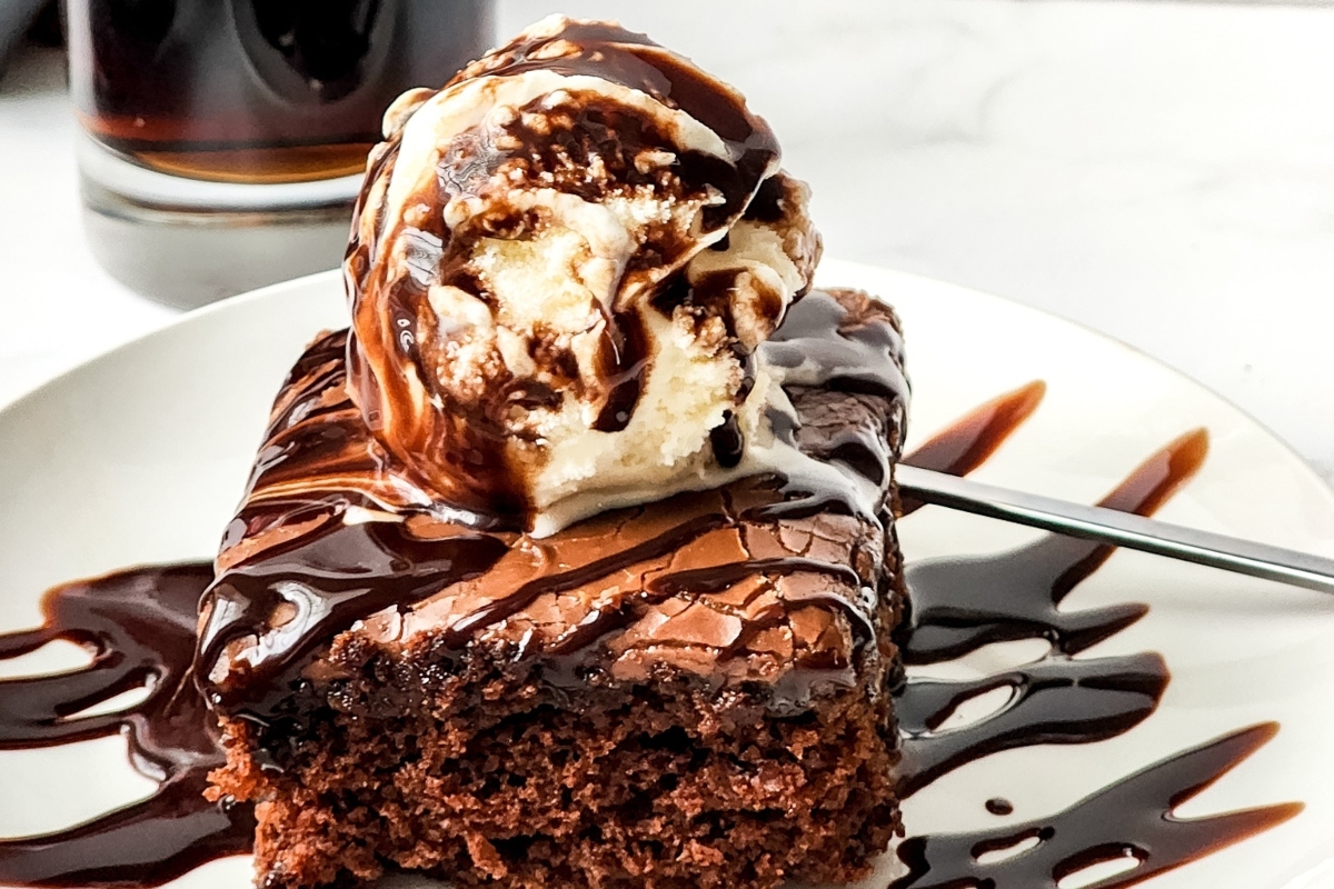 A slice of chocolate cake with ice cream and a scoop of ice cream.