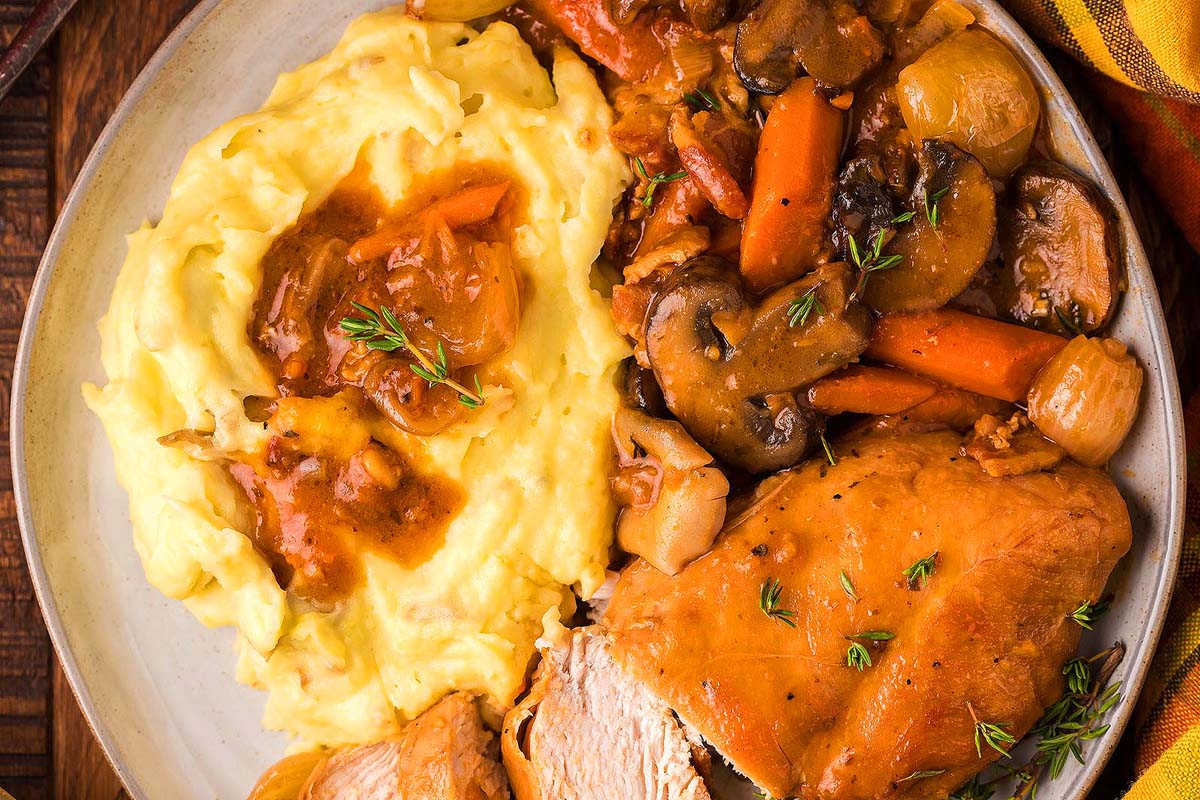 A plate with mashed potatoes and roast chicken on it.