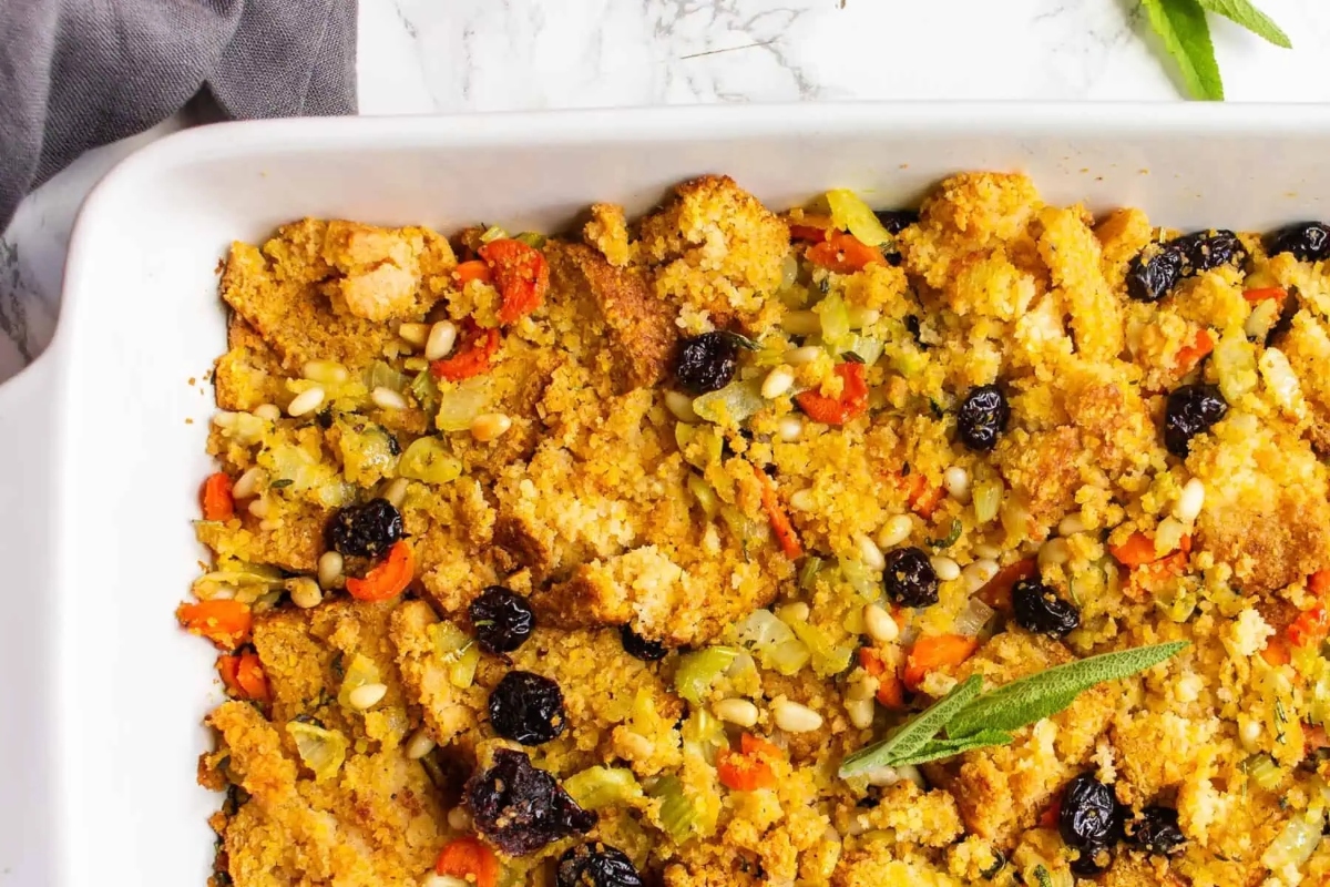 A white baking dish filled with delicious stuffing and adorned with fragrant sprigs of sage.