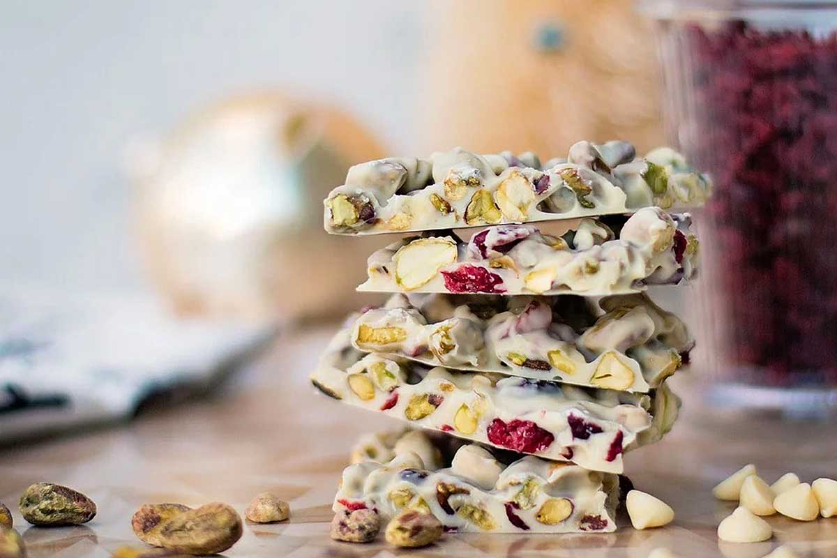 A stack of white chocolate and pistachio bars on a table, perfect for those craving a delectable treat bursting with the rich flavors of pistachio and creamy white chocolate.