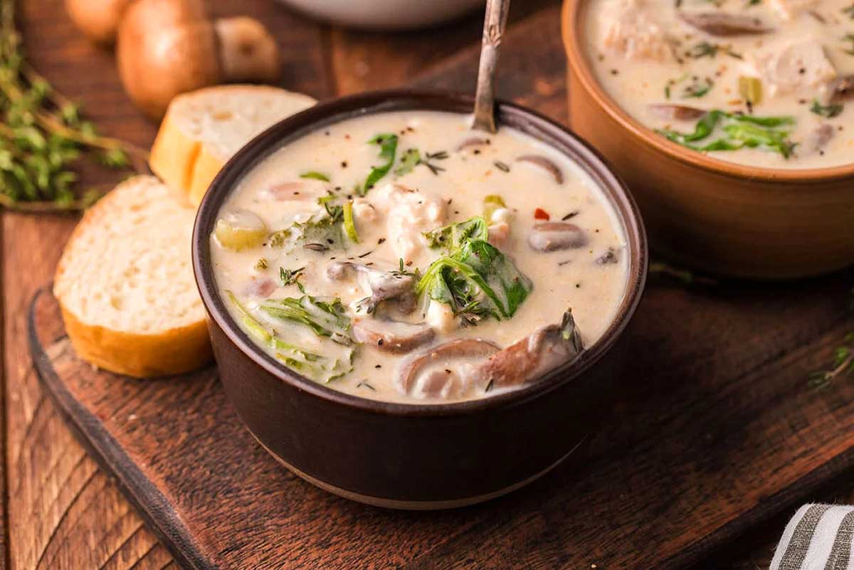 Two bowls of mushroom soup on a wooden cutting board, perfect for any occasion.