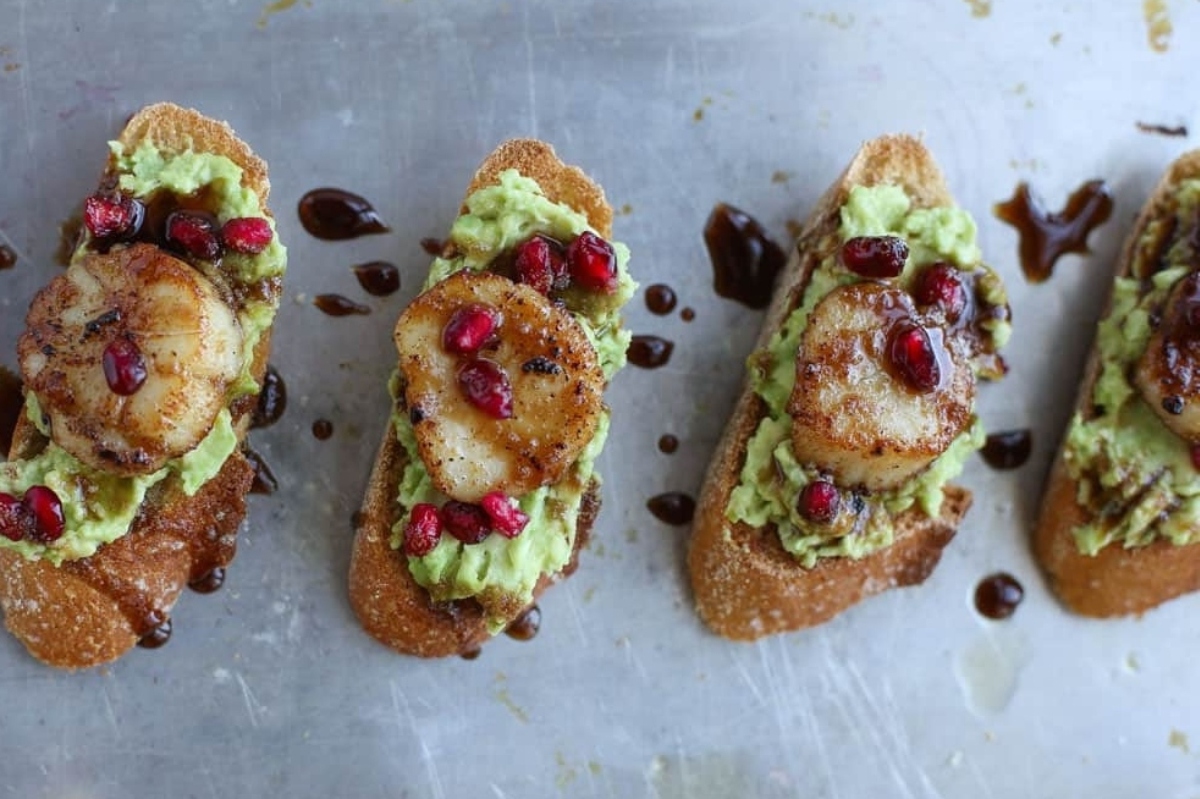Appetizers for New Year's Eve: Scallops with avocado and pomegranate crostini.
