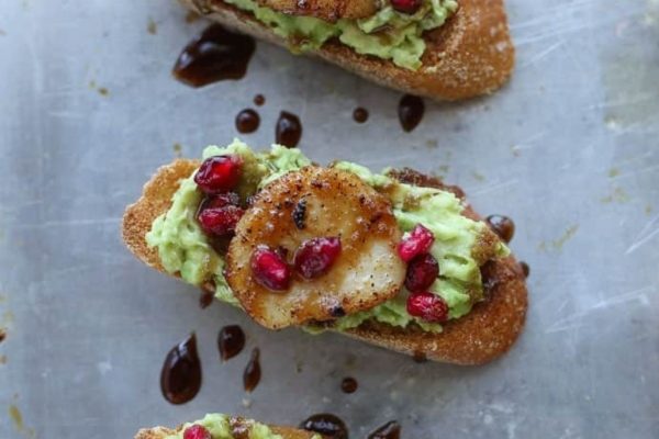 Scallop crostini with guacamole and pomegranate.