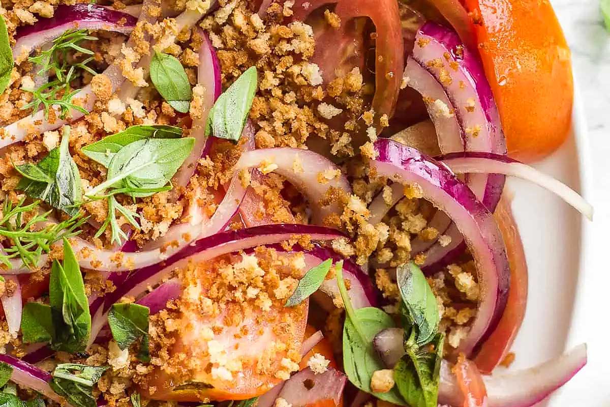 A plate with tomatoes and herbs on it, perfect for making delicious tomato recipes.