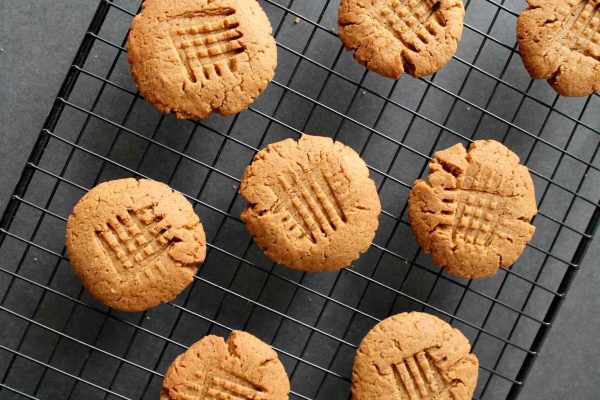 Peanut butter cookies on a cooling rack for a potluck gathering.