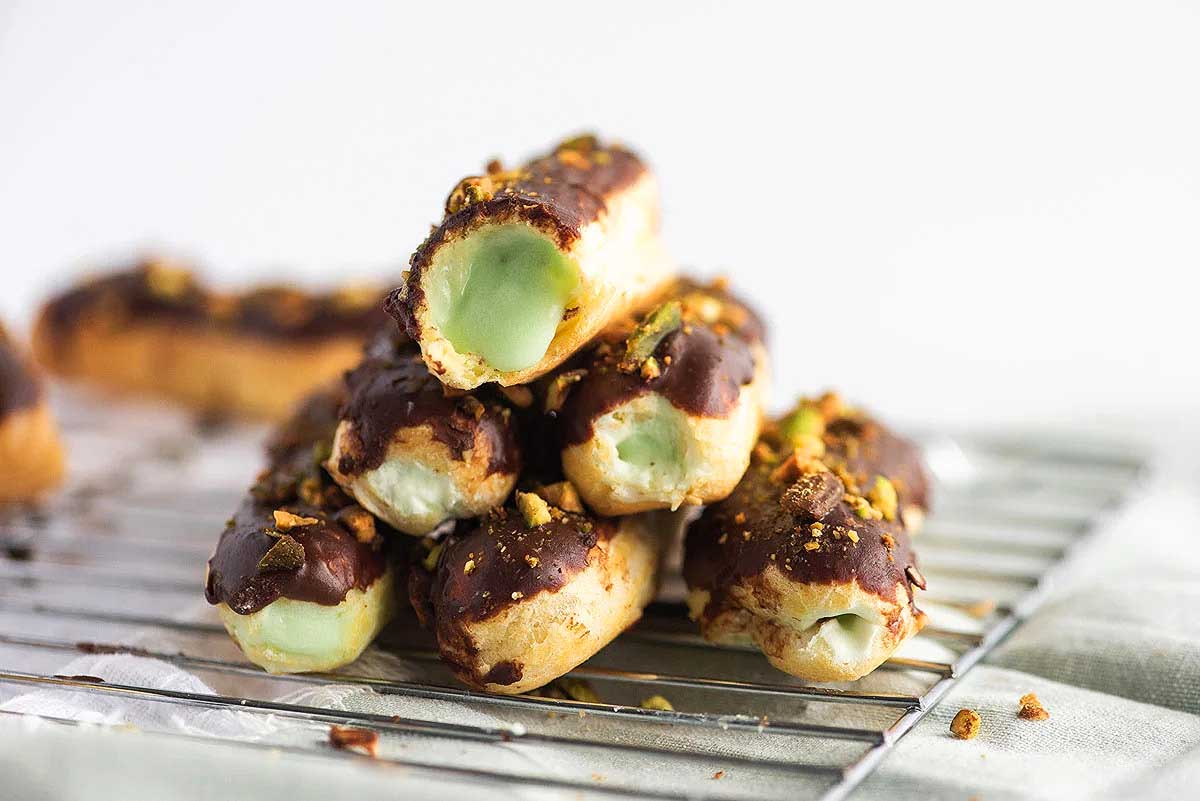 A stack of chocolate covered pastries on a cooling rack, perfect for those who love indulging in delicious recipes.
