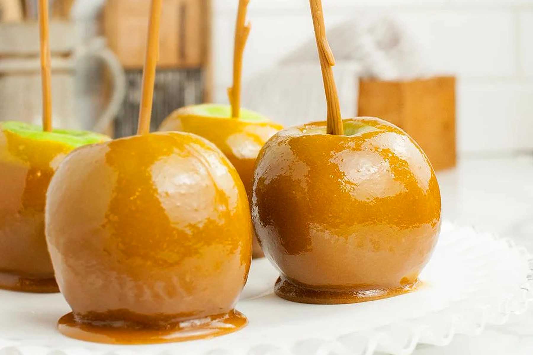 Caramel apples with caramel sauce on a plate.