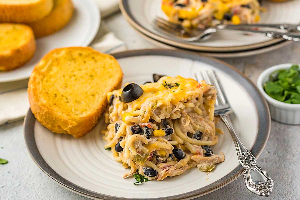 Mexican chicken casserole on a plate with bread on the side.