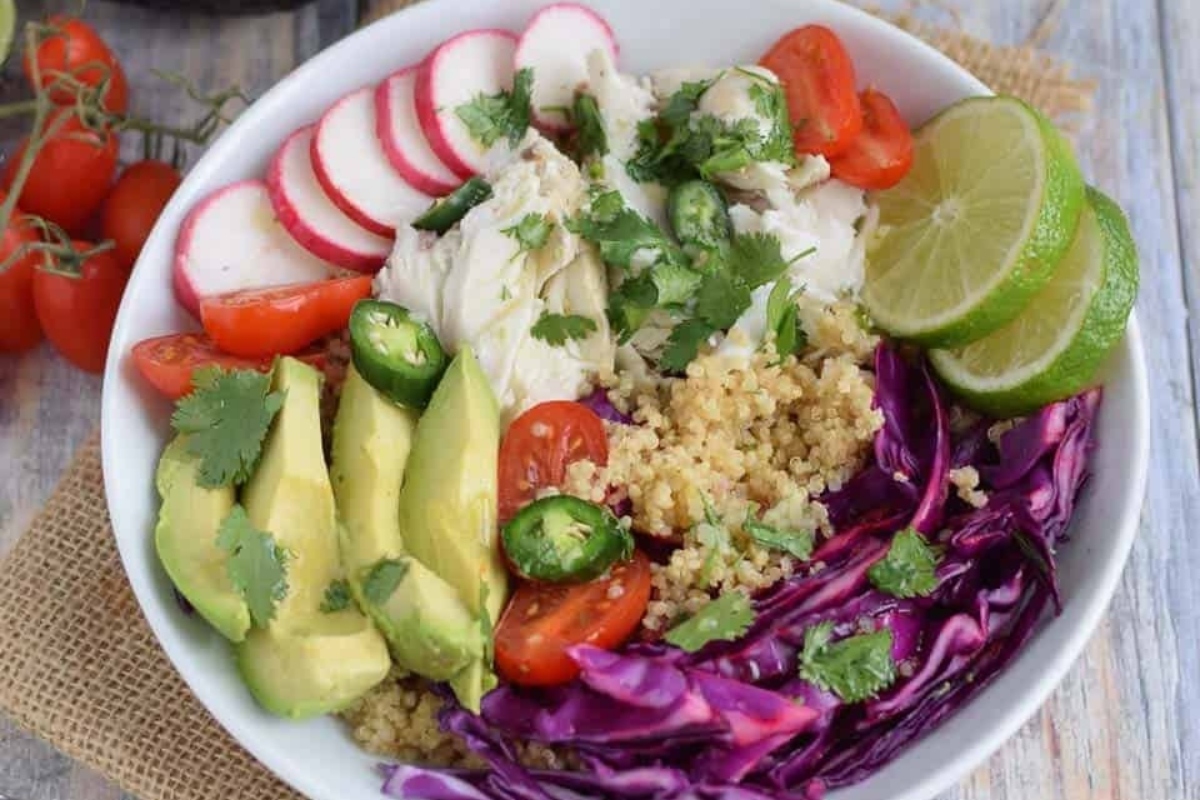 A bowl of quinoa salad with red cabbage, radishes and avocado.