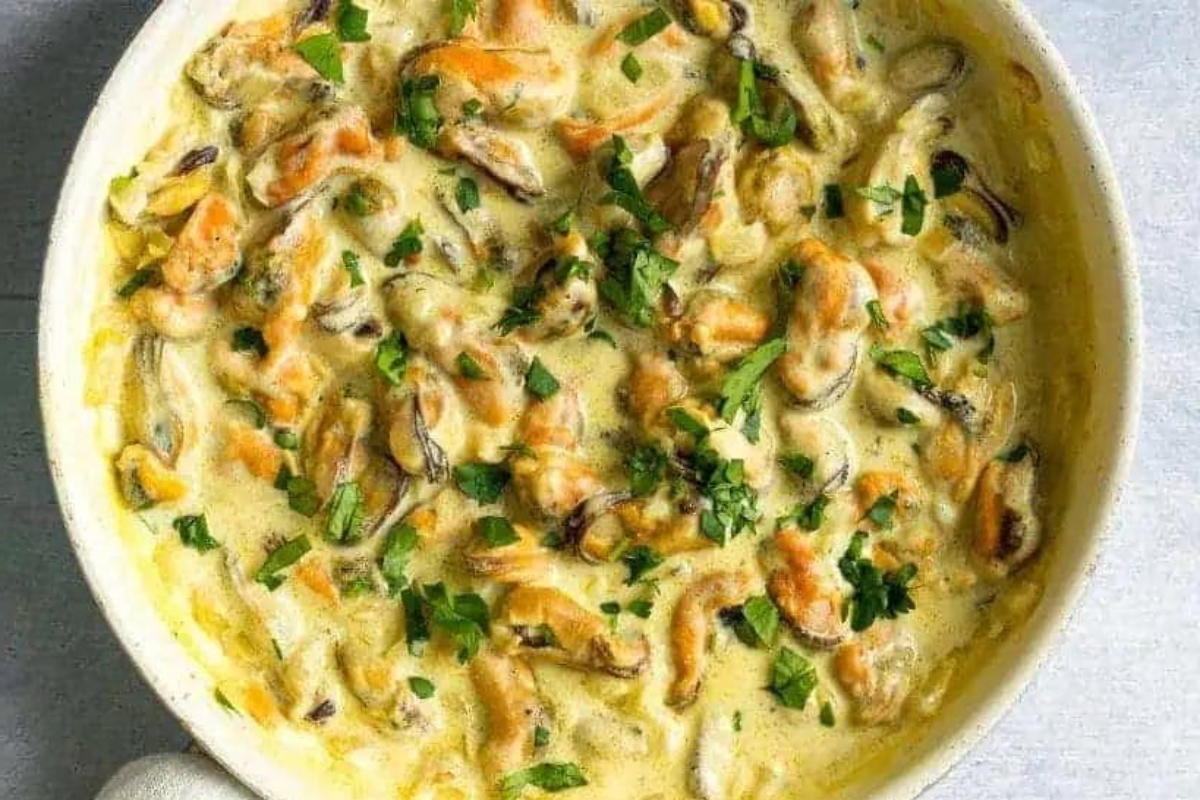 A white dish with shrimp and mushrooms in it.