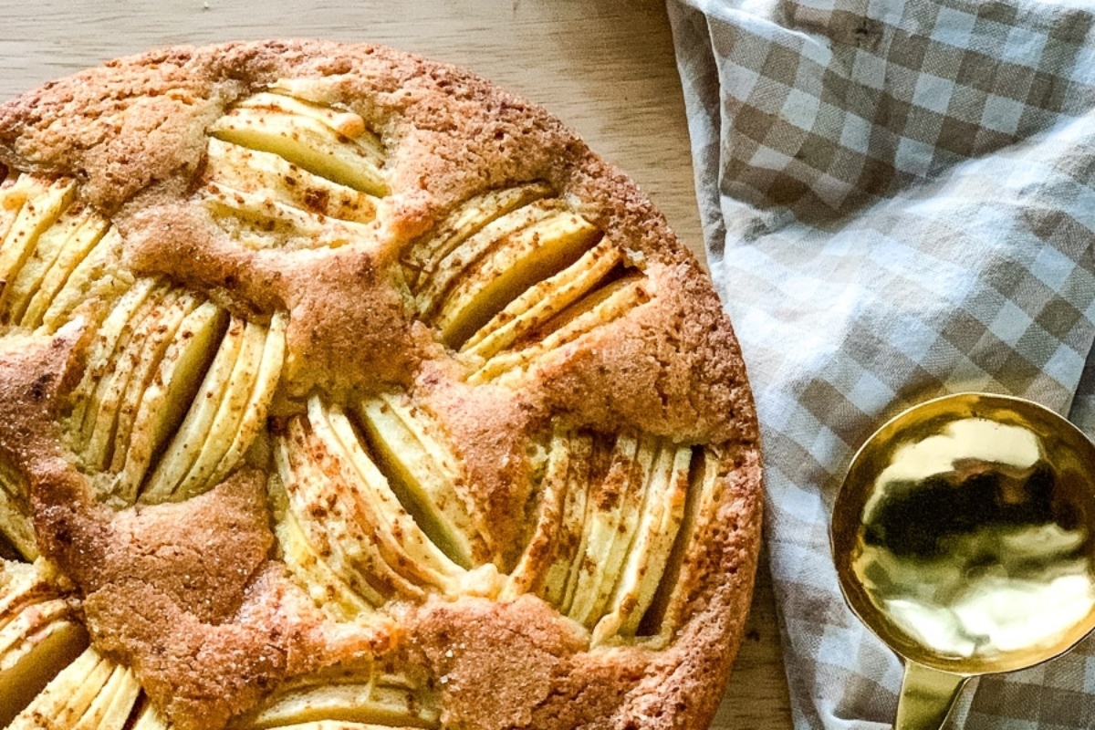 A German apple cake recipe on a table with a spoon.