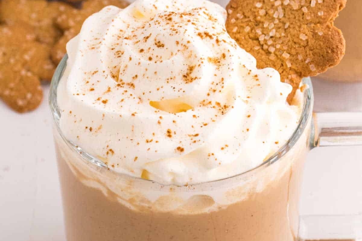 Gingerbread latte with whipped cream and gingerbread cookies, perfect for the holiday season.