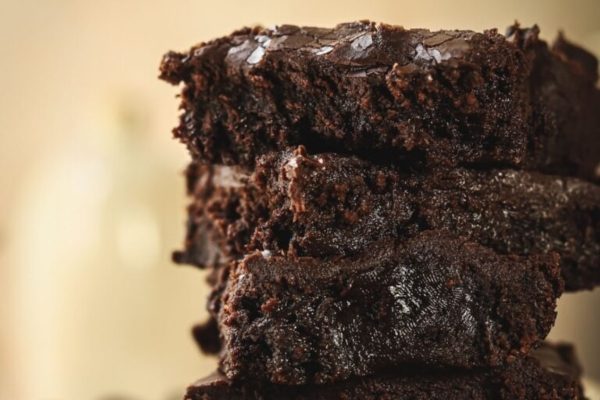 A stack of chocolate brownies on a plate.