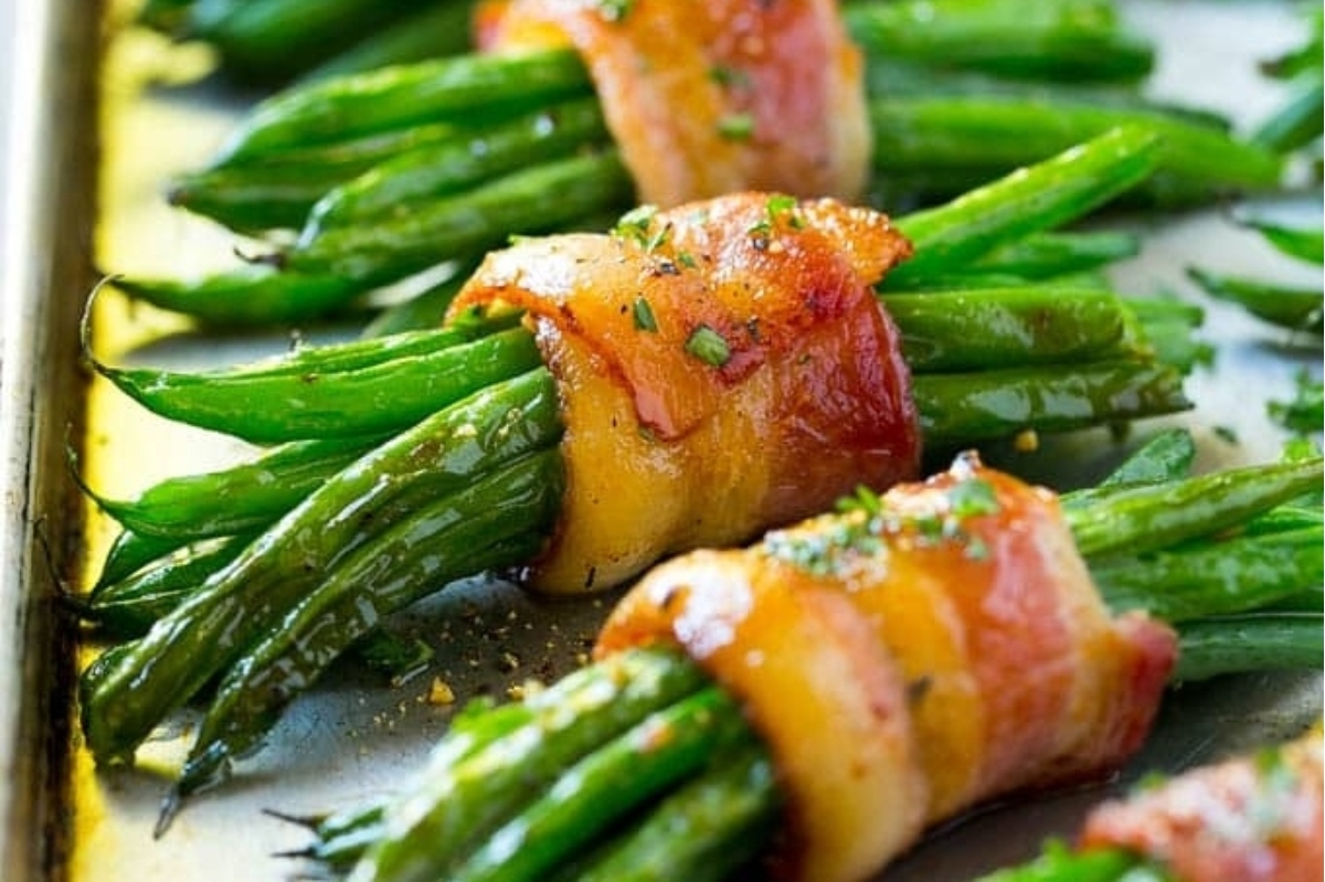 Thanksgiving recipe for bacon wrapped green beans on a sheet pan.