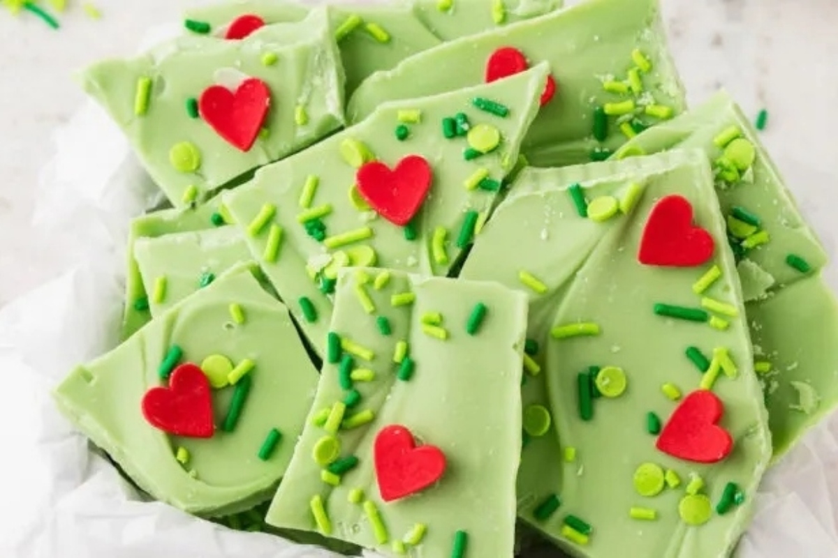 A bowl of green chocolate bark with sprinkles and hearts, perfectly resembling the Grinch's favorite holiday treat.