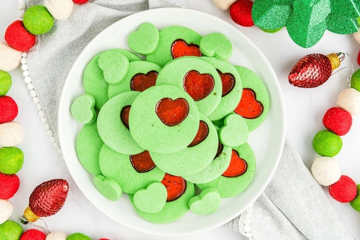 A plate of green cookies with hearts on it, perfect for the holiday season or for any Grinch-inspired party.