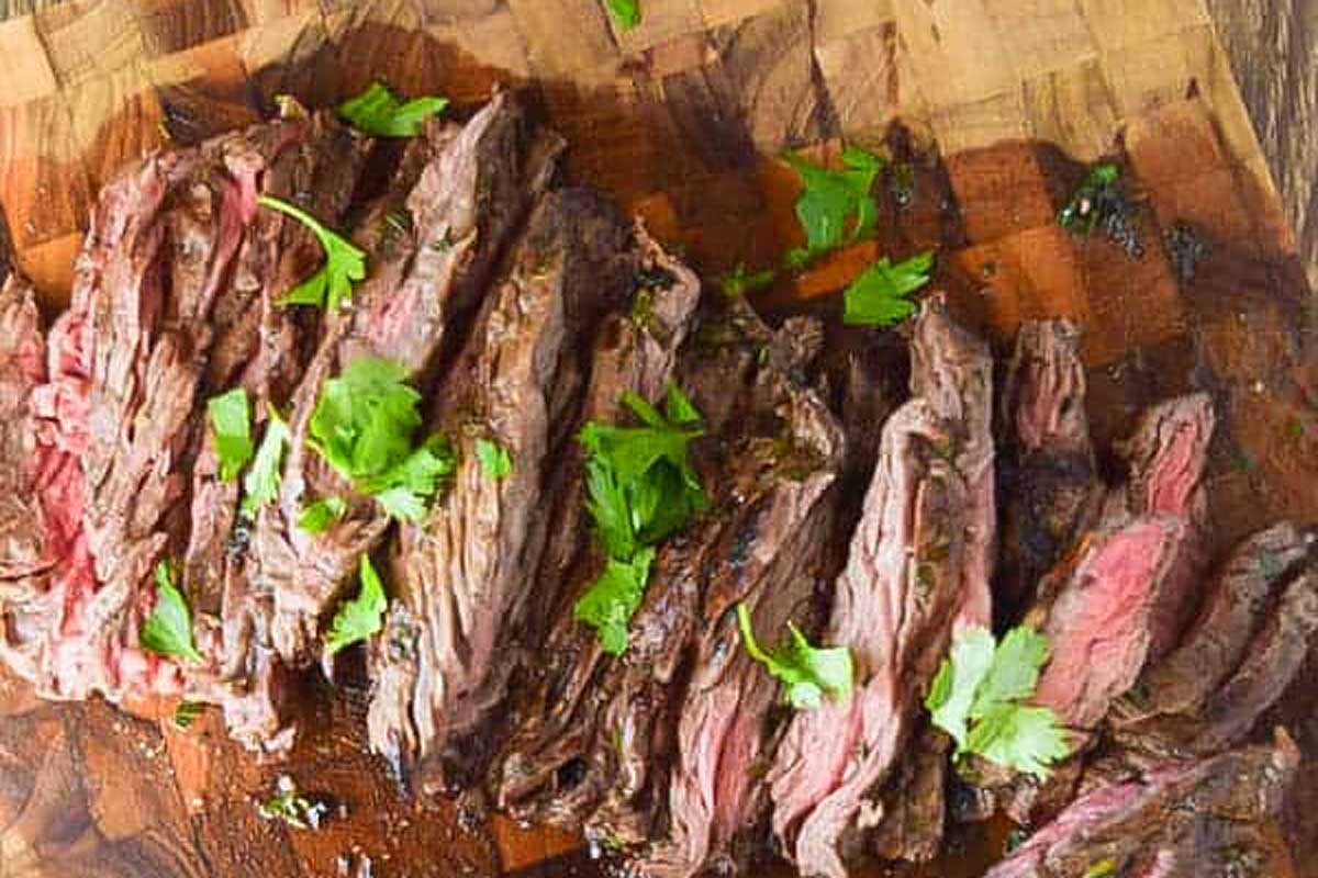 Grilled steak on a wooden cutting board.