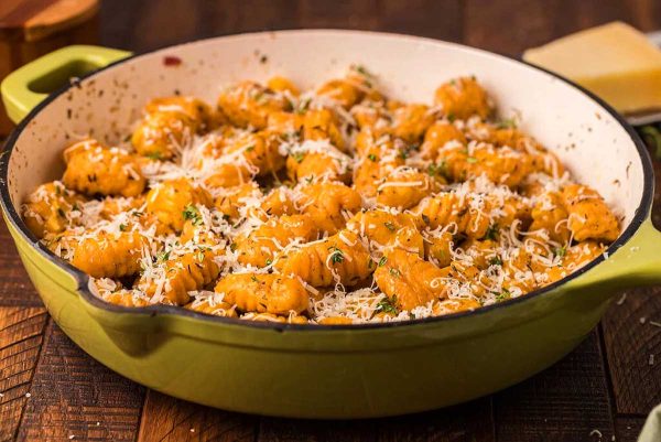 Fettuccine in a green pot with parmesan cheese and gnocchi recipes.