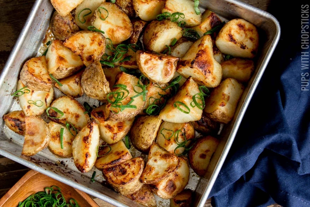 Roasted potatoes in a baking dish with green onions.