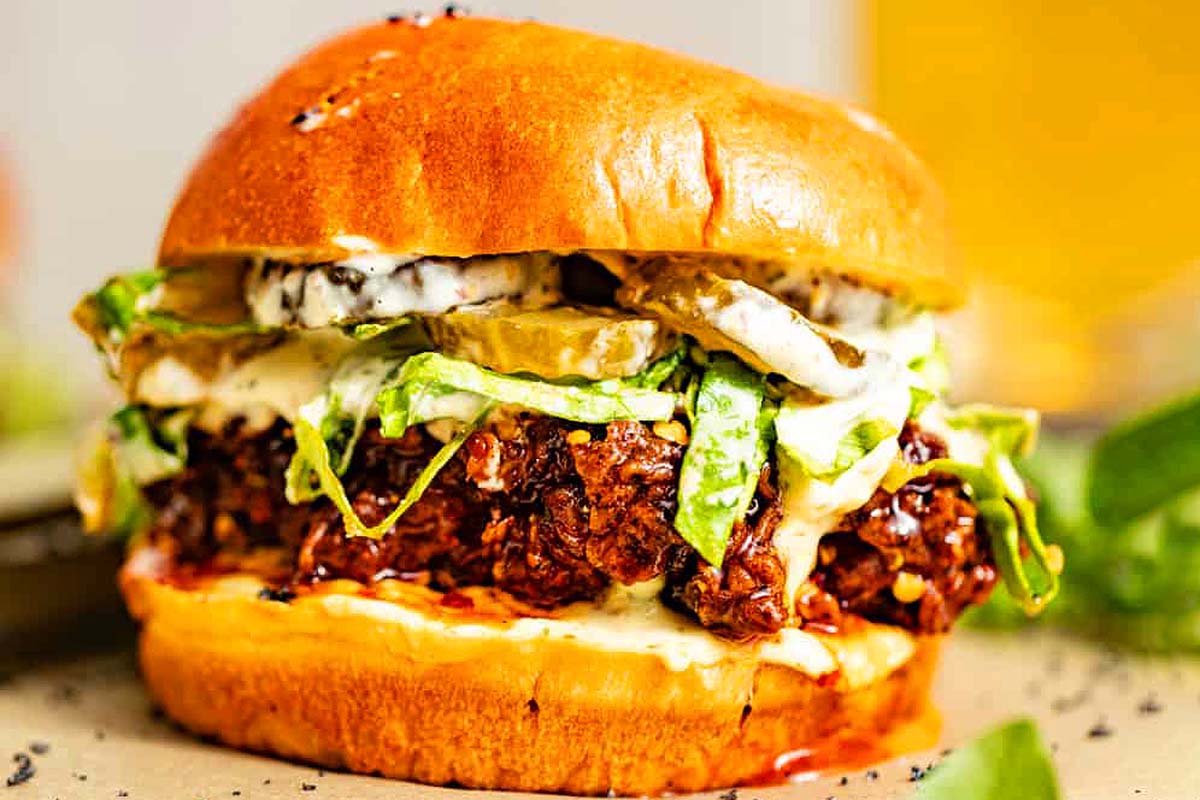 A burger is sitting on top of a wooden board.