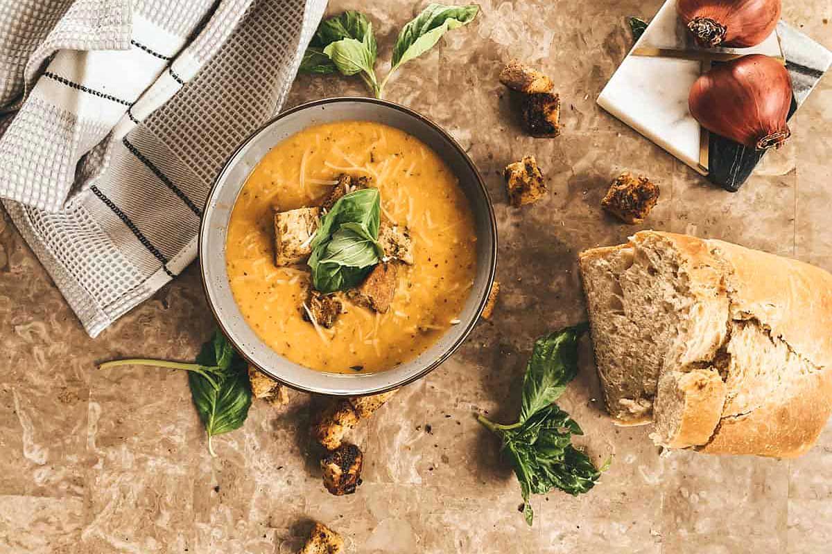 A bowl of soup and bread on a table.