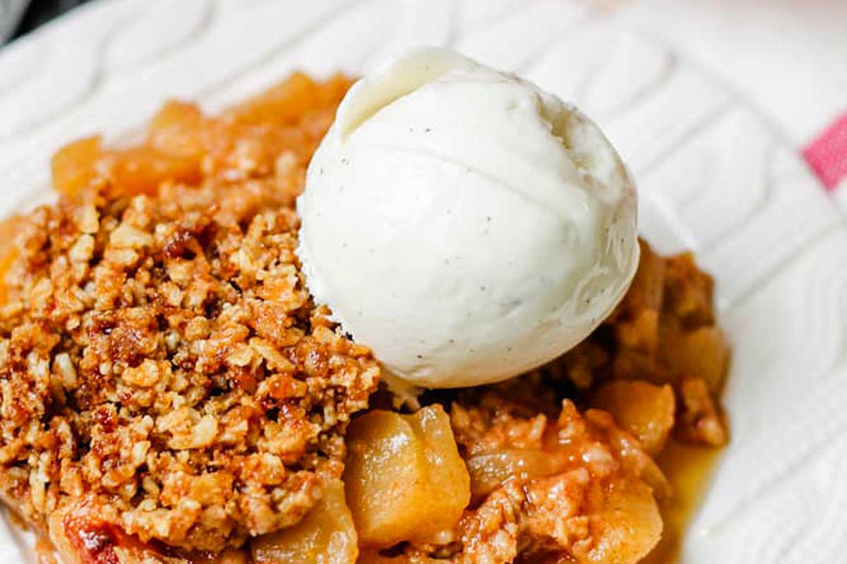 Apple crisp with ice cream, served on a plate.