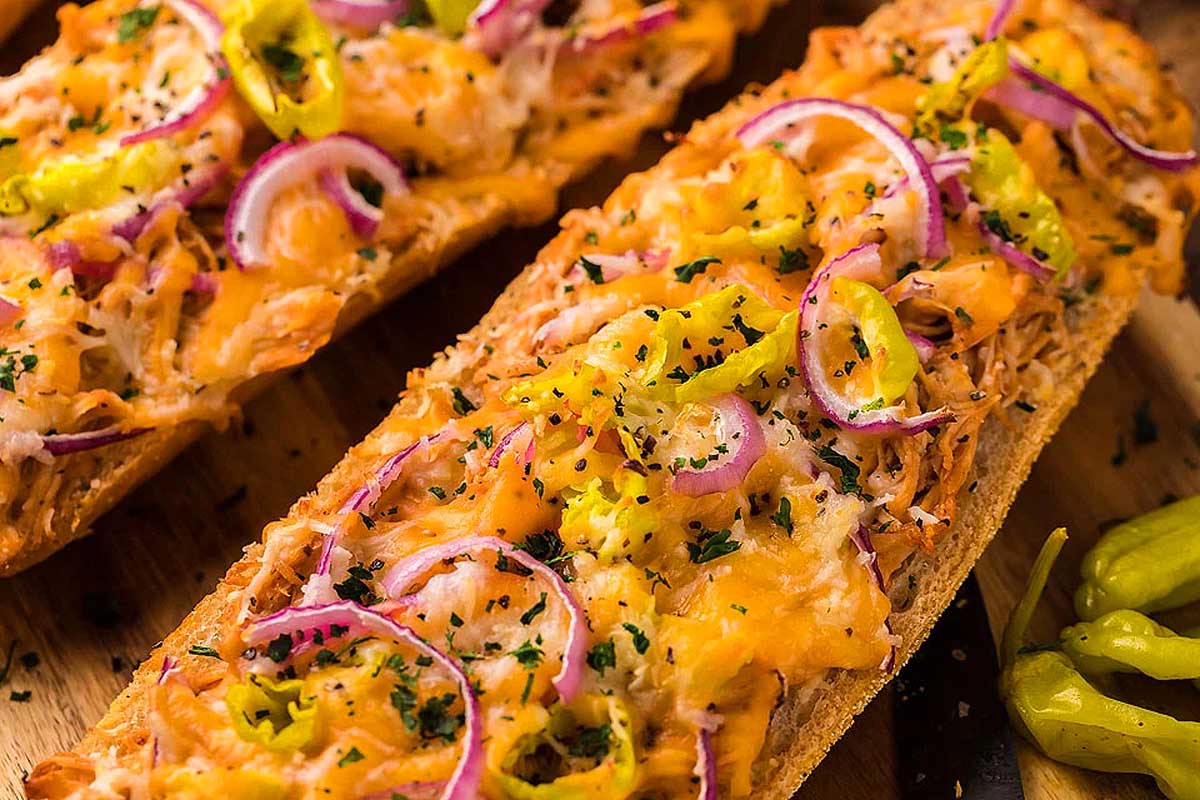 A slice of bread with onions and peppers on it.