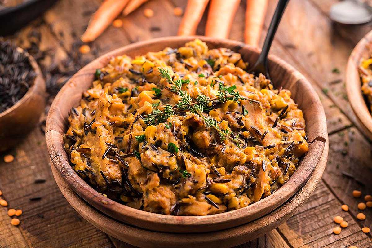 A bowl of black rice and carrots on a wooden table, perfect for an Instant Pot Thanksgiving feast.