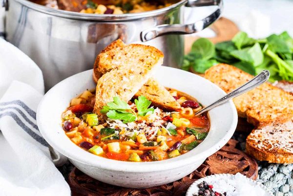 A bowl of soup with bread next to it.