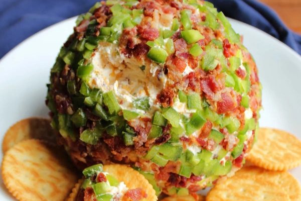 This recipe features a delicious bacon cheese ball served on a plate with crackers.