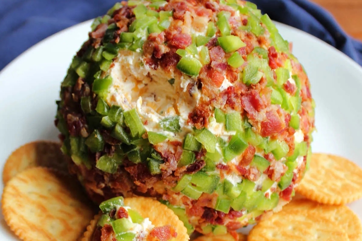 This recipe features a delicious bacon cheese ball served on a plate with crackers.