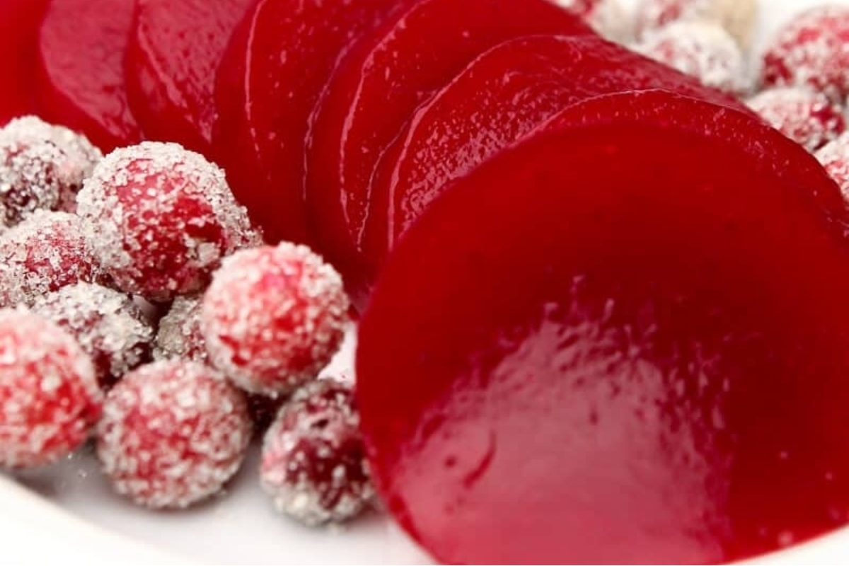 Delicious cranberry sauce recipes served on a white plate with sugar sprinkled on top.