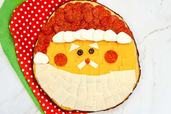 A Christmas-themed pizza with a santa claus face on it.