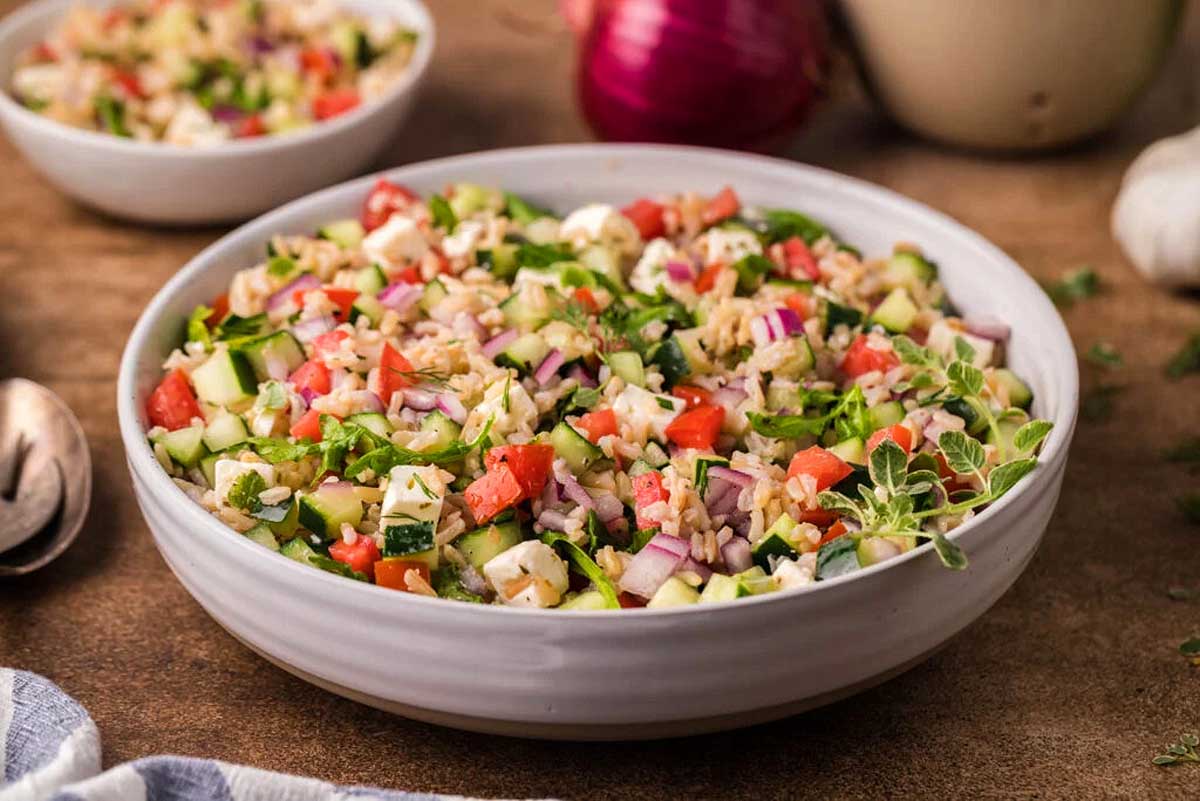 Greek salad in a bowl on a wooden table.