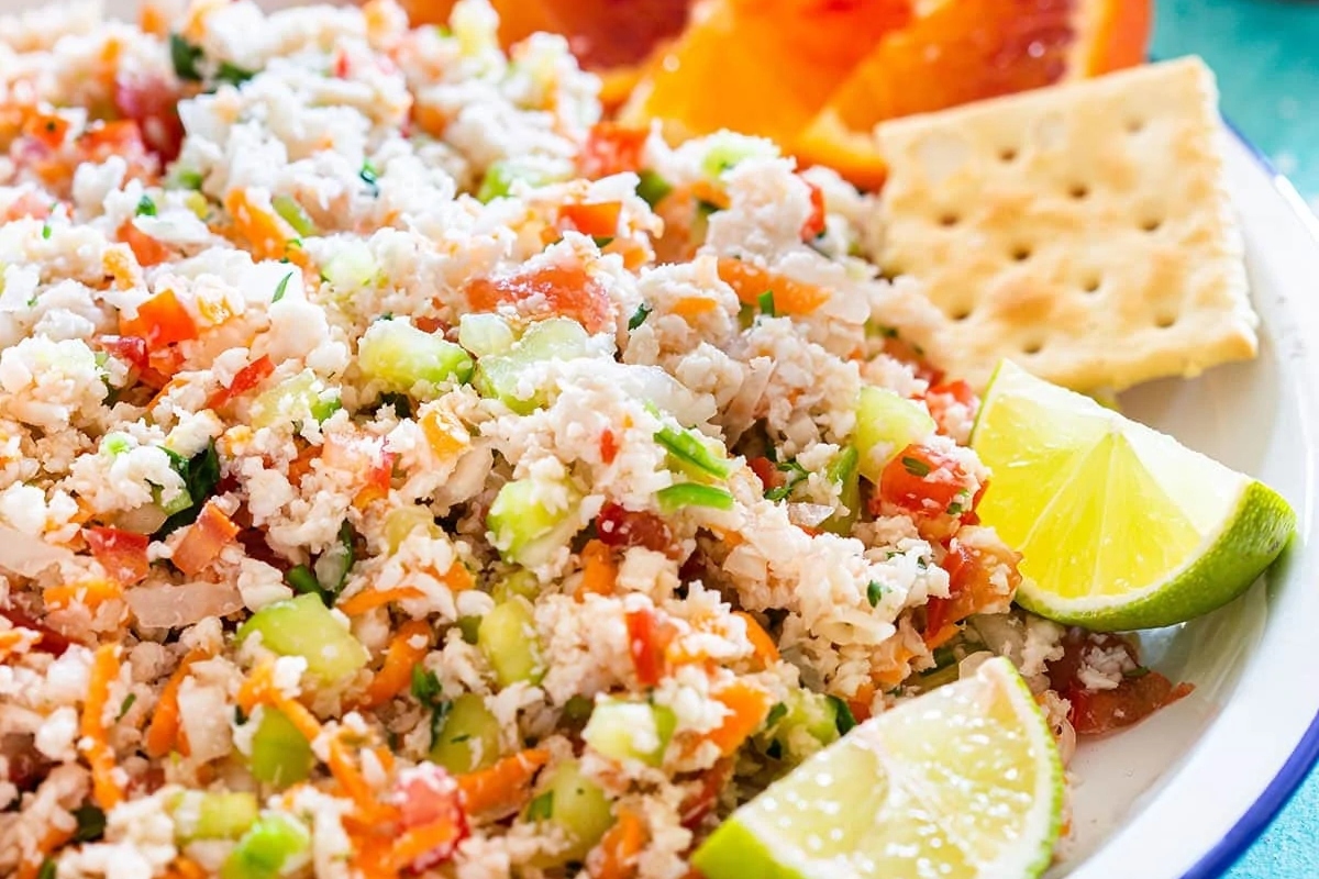 A plate with rice, carrots and limes on it.