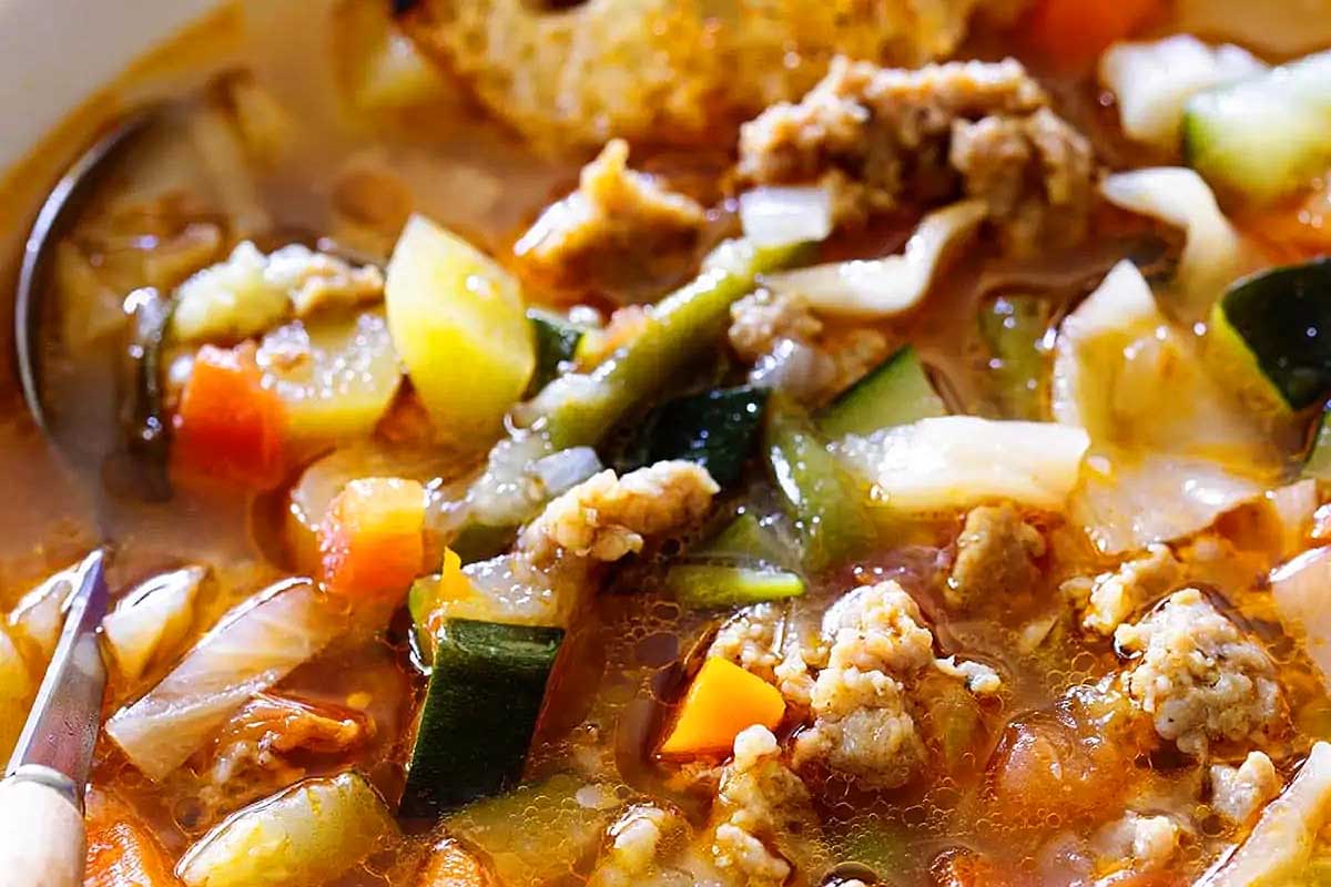 A bowl of soup with meat and vegetables.