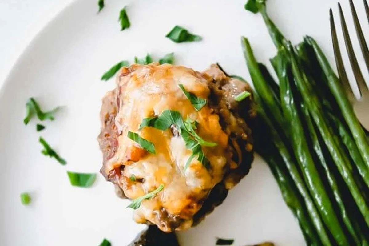 A plate of cheesy steak and asparagus with a meatloaf inspired twist.