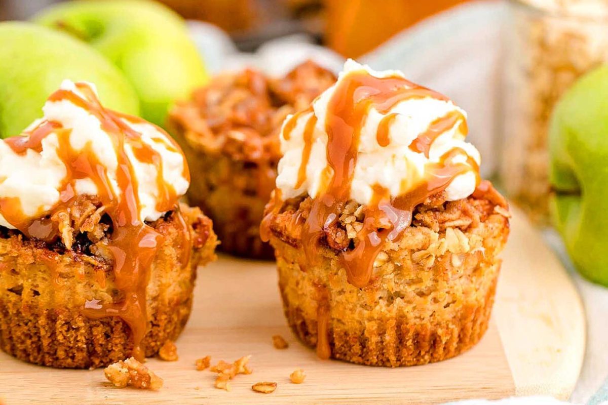 Caramel apple muffins on a wooden cutting board.