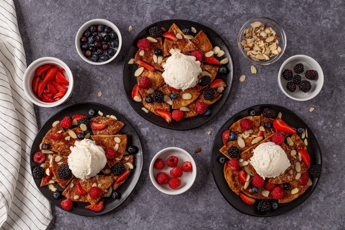 A plate of pancakes with berries and ice cream.