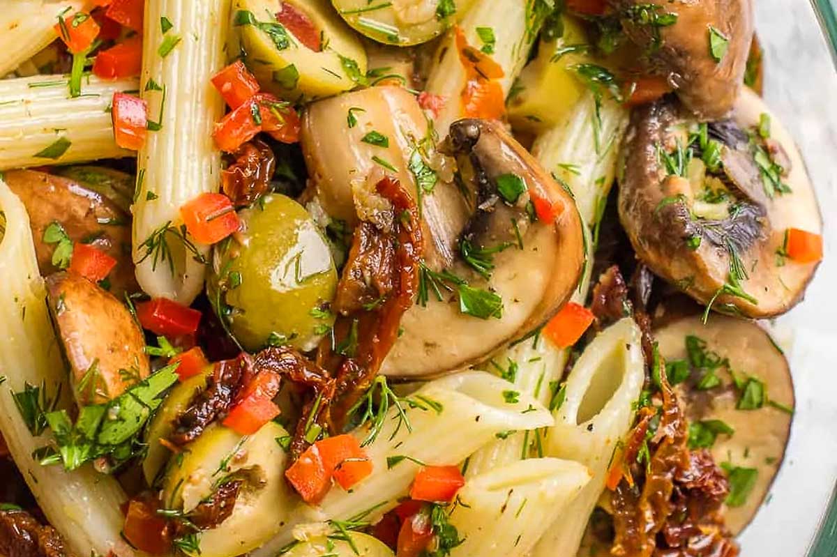 A bowl of pasta with mushrooms and herbs, perfect for a satisfying meal.