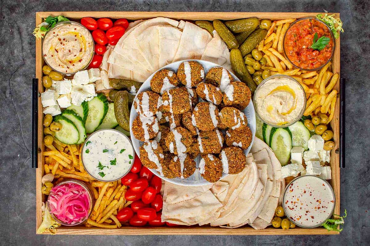 A wooden tray with a variety of food on it.