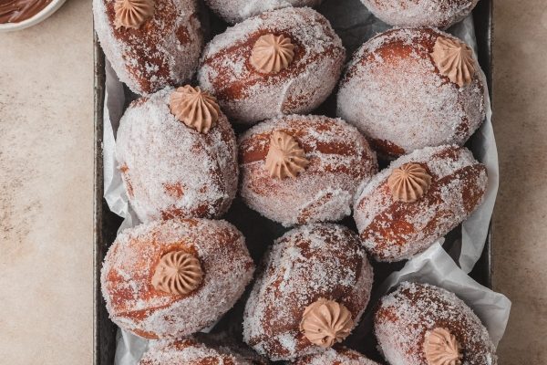 A tray of donuts covered in powdered sugar.