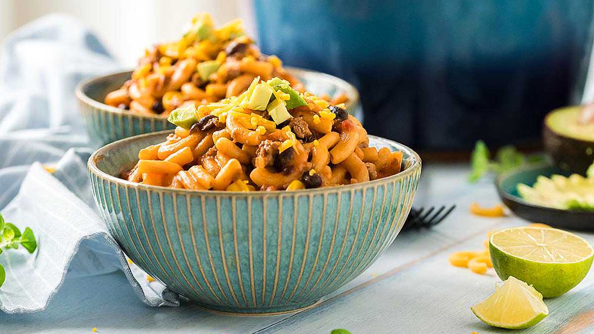 Two bowls of mexican macaroni and cheese on a table.