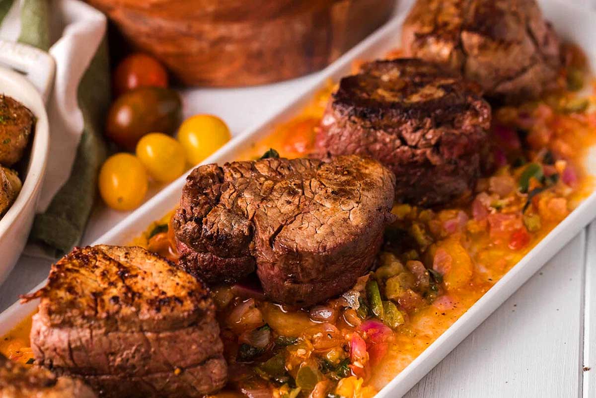 Beef tenderloin with tomato sauce served on a white plate, perfect for a romantic date night. This is one of the best date night dinner ideas.