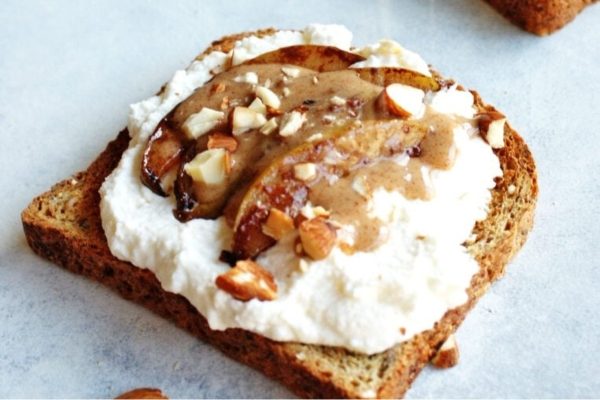 A toast with whipped cream and nuts on it.
