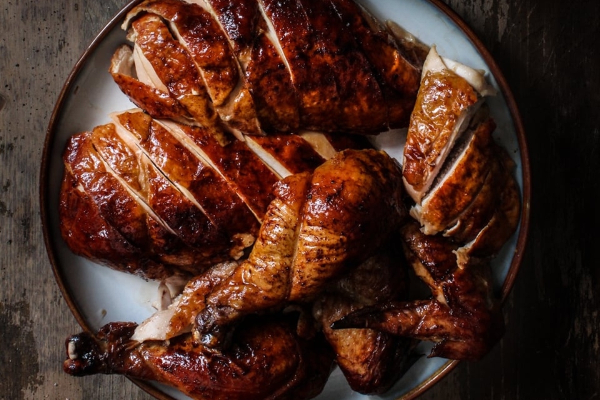 Roasted turkey on a plate on a wooden table.