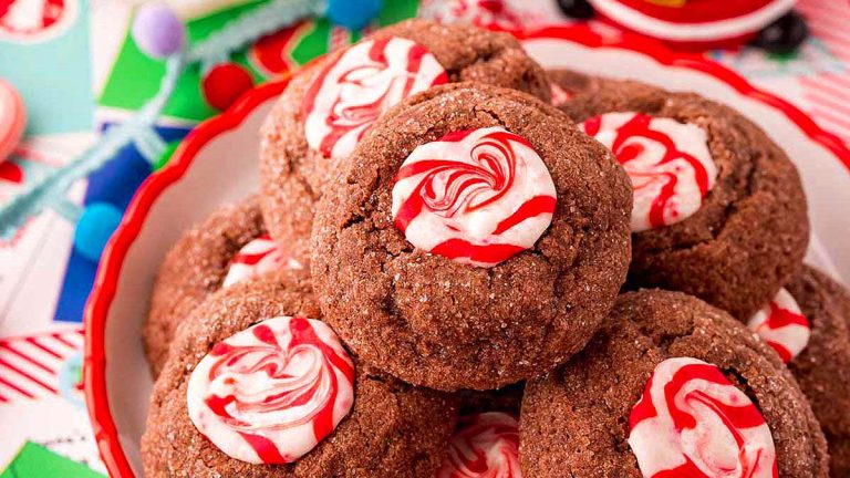 Peppermint thumbprint cookies adorned with candy canes placed delicately on a plate.
