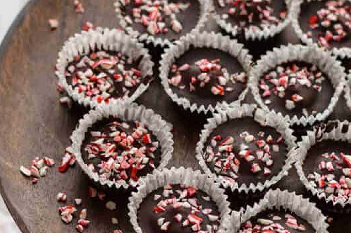Candy cane truffles on a wooden plate.