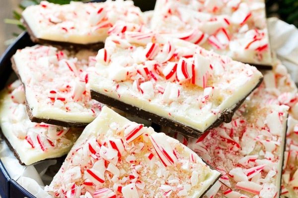Peppermint bark in a bowl with candy canes.